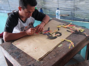 Puppet maker painting the hide.